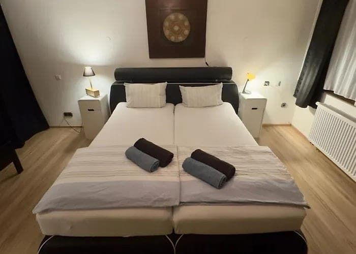 Doppelbett mit weißen Decken und braunen Handtüchern
