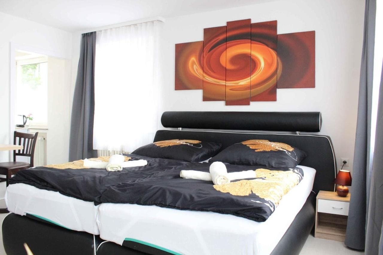 Doppelzimmer mit weißer Bettwäsche und Spiral-Kunstwerk
