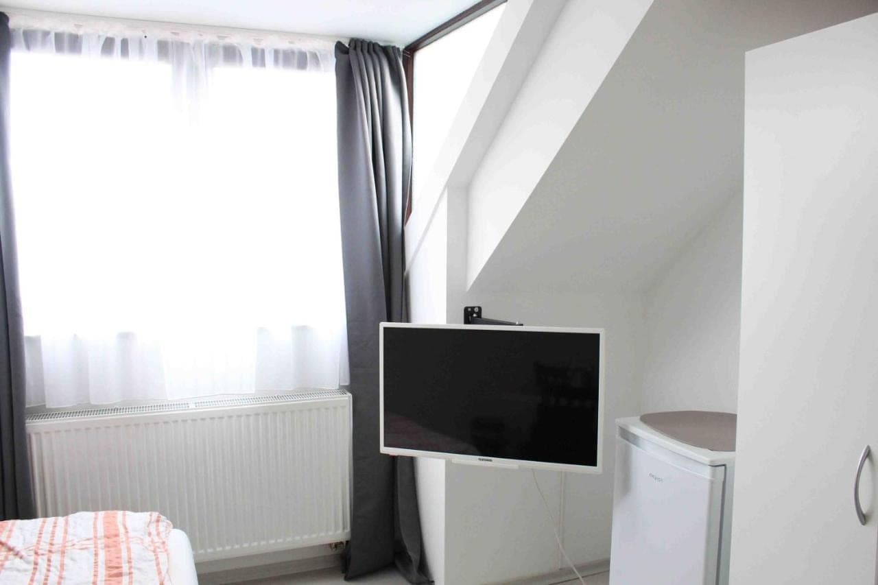 Zimmer unterm Dach mit TV und rundem Tisch