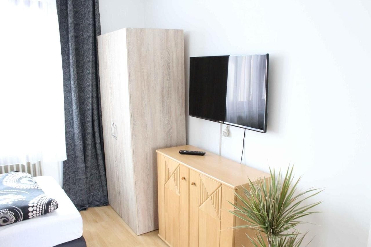 Wohnbereich mit TV, Sideboard und Pflanze