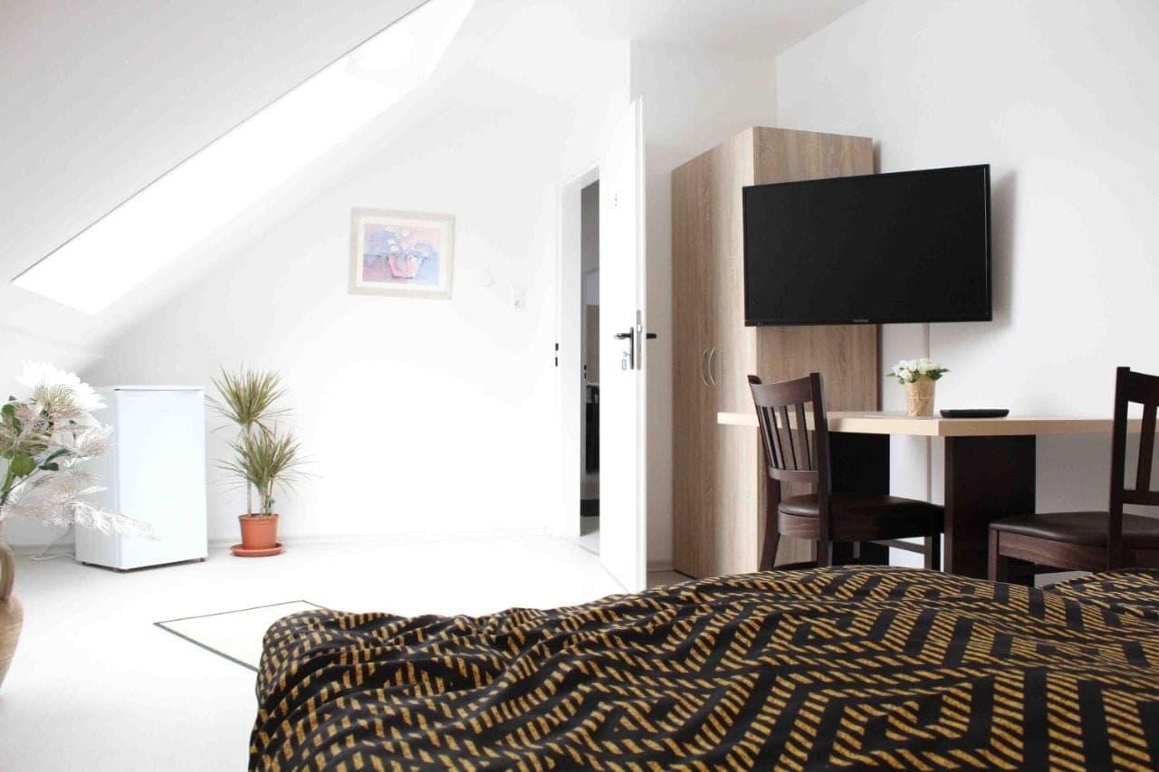 Apartment mit gemustertem Bett, TV und Essplatz