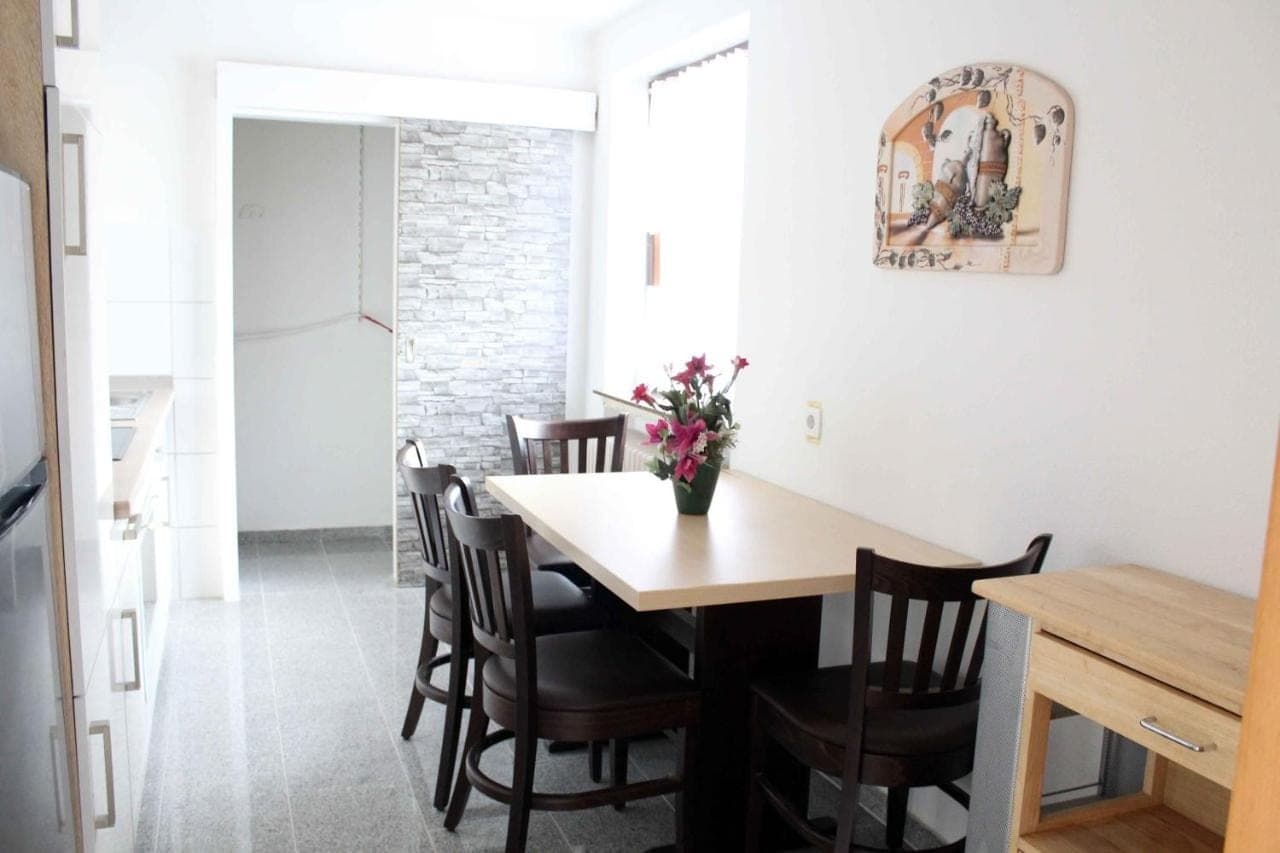 Essbereich mit dunklem Holztisch und frischen Blumen