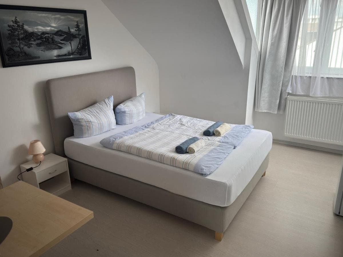 Helles Schlafzimmer mit grauem Polsterbett