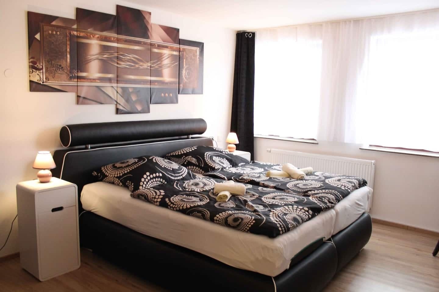 Schlafzimmer mit Kunstpanel über dem Doppelbett