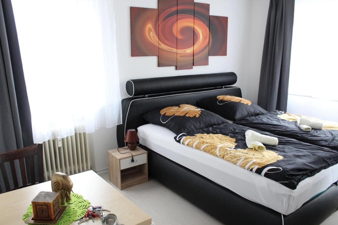 Doppelzimmer mit schwarzem Lederbett und goldener Wäsche