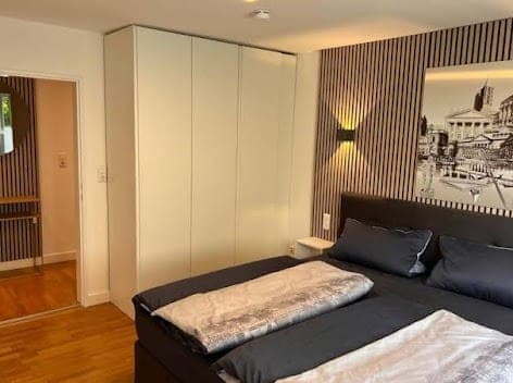Schlafzimmer mit Fototapete und großem Kleiderschrank